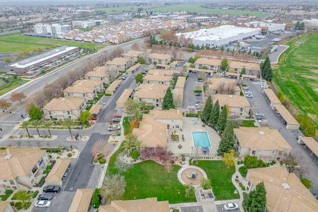 an aerial view of residential houses with outdoor space and parking