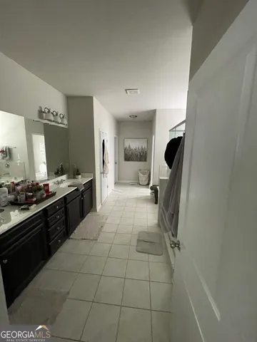 a large white kitchen with a sink stainless steel appliances and cabinets