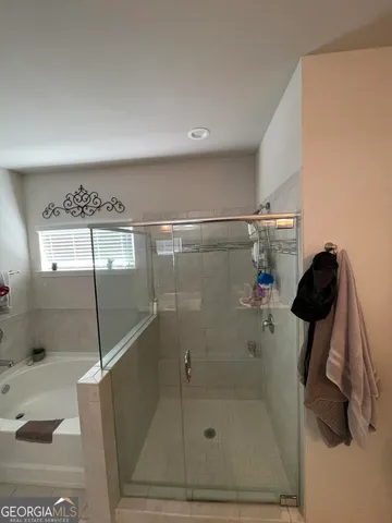 a bathroom with a bathtub and mirror