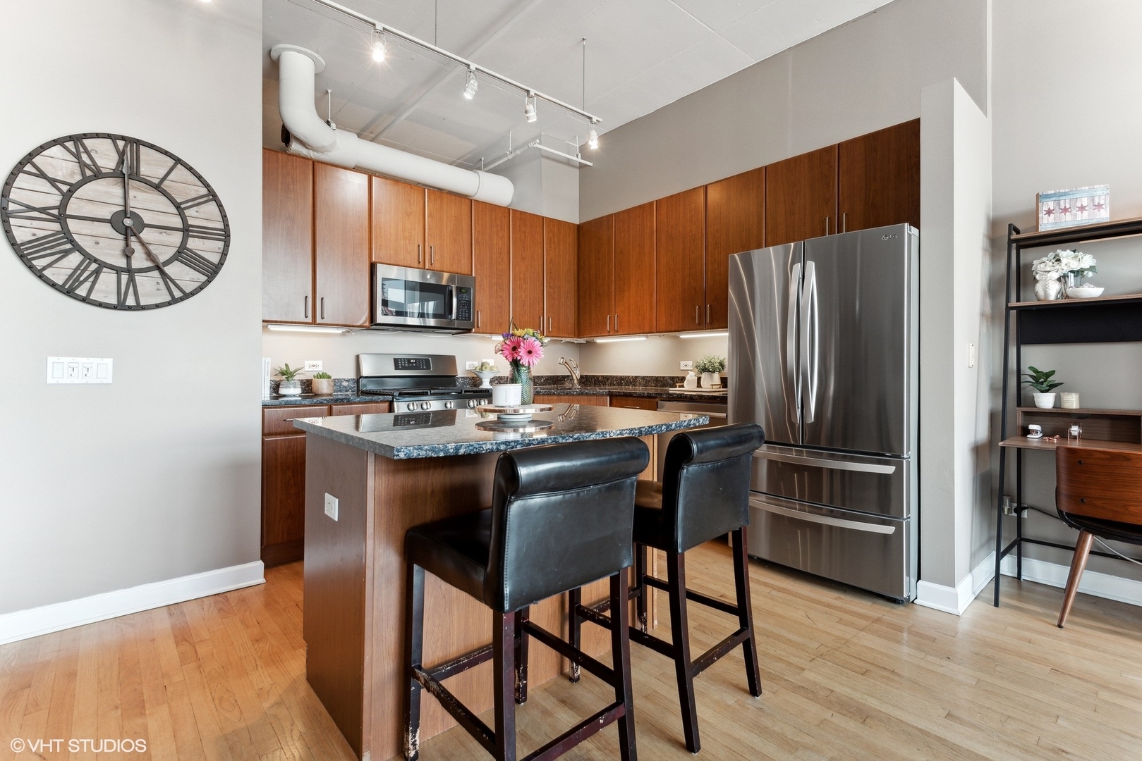 1301 West Madison Street, Unit 603 Chicago, IL 60607 - Photo 8 of 24 a kitchen with stainless steel appliances granite countertop a refrigerator a stove a sink and a dining table with wooden floor