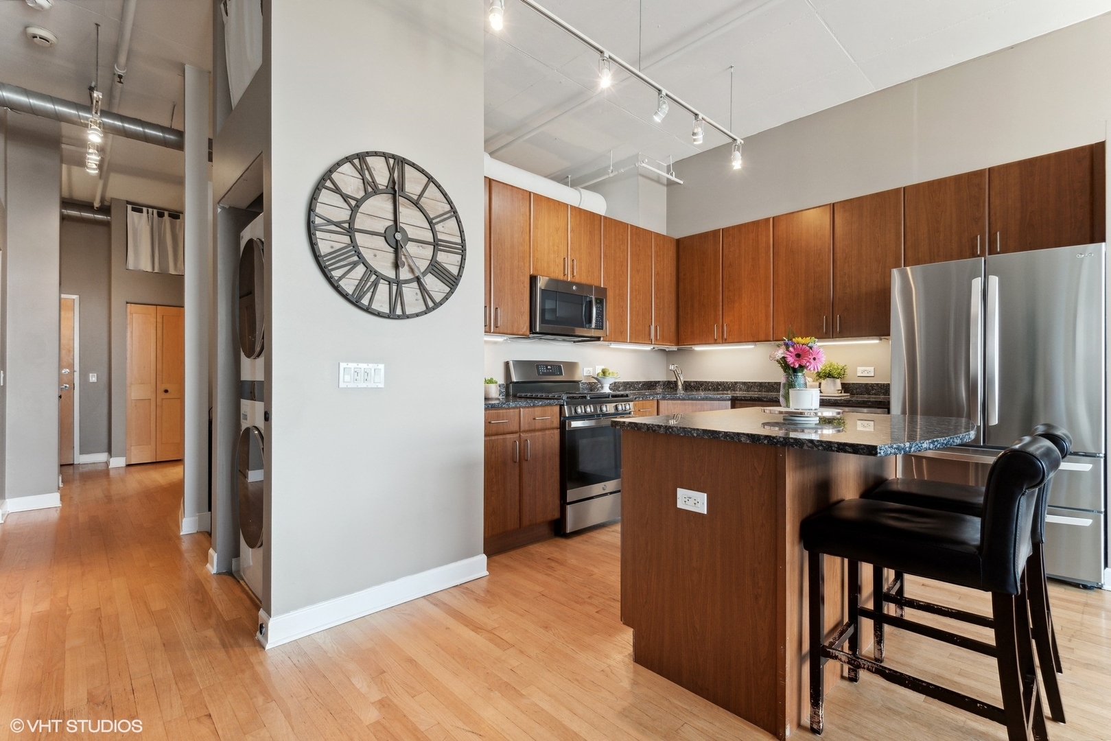 1301 West Madison Street, Unit 603 Chicago, IL 60607 - Photo 10 of 24 a kitchen with stainless steel appliances granite countertop a refrigerator a stove a sink and a dining table with wooden floor