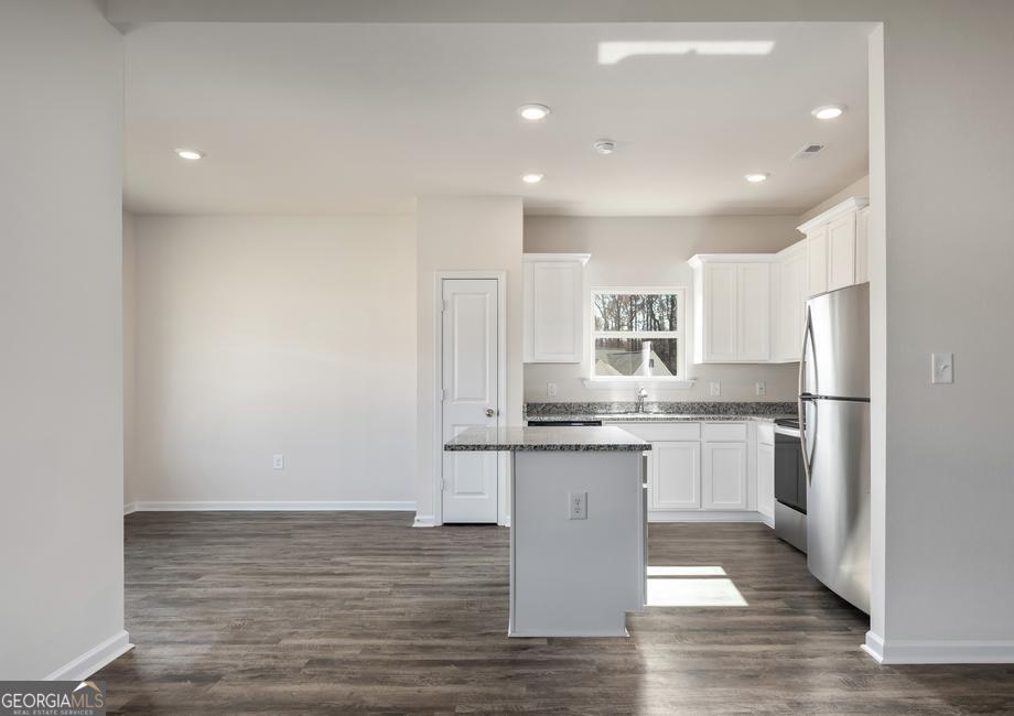 115 Darter Court Hoschton, GA 30548 - Photo 4 of 8 a kitchen with stainless steel appliances granite countertop a sink stove and refrigerator