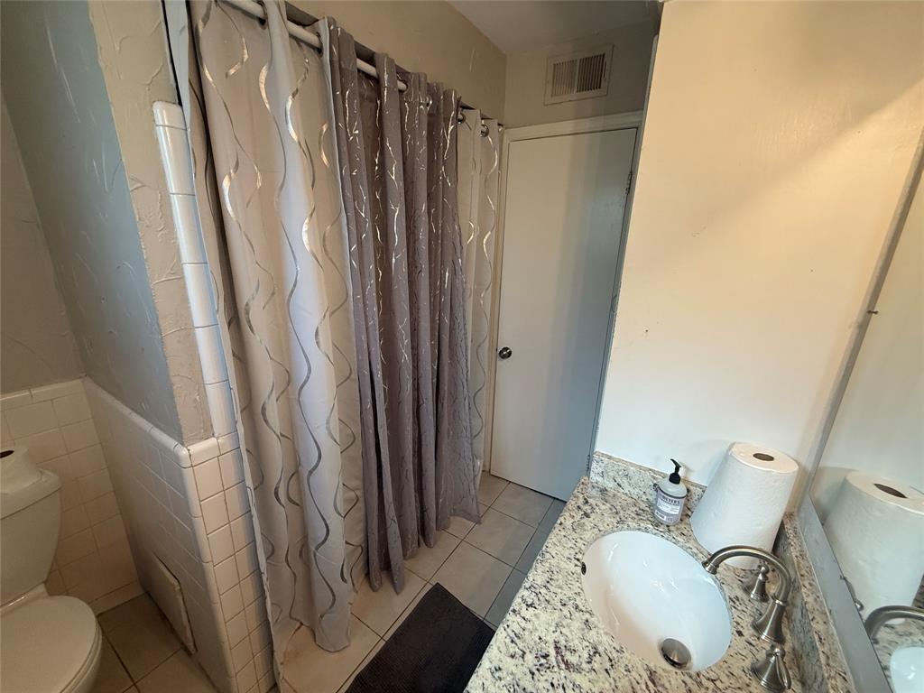 2888 Reedcroft Drive Farmers Branch, TX 75234 - Photo 15 of 32 a bathroom with a sink a toilet and shower curtain