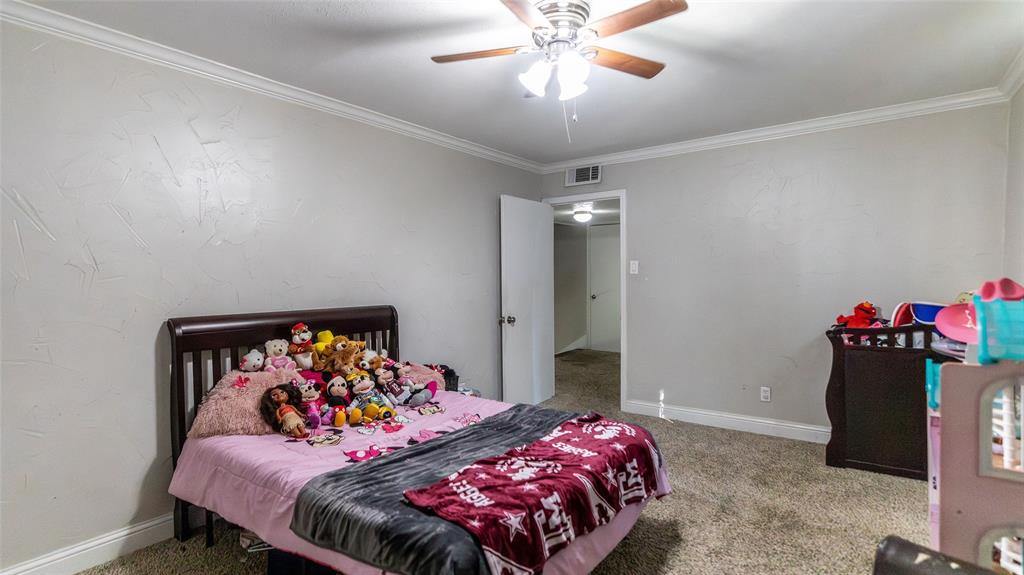 2888 Reedcroft Drive Farmers Branch, TX 75234 - Photo 19 of 32 a bedroom with a bed and a chandelier