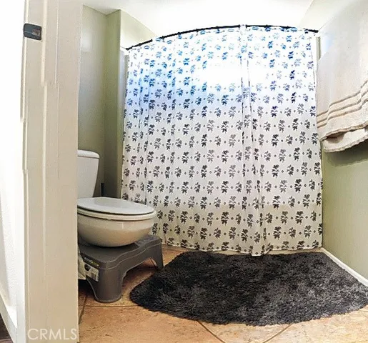a bathroom with a toilet and a shower curtain