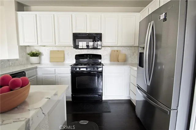 a kitchen with a refrigerator stove and white cabinets