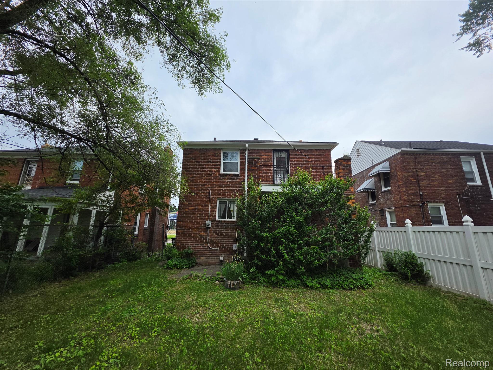 15832 Griggs Street Detroit, MI 48238 - Photo 7 of 24 Rear exterior featuring brick construction, a second-story balcony with metal railing, and a ground-level window