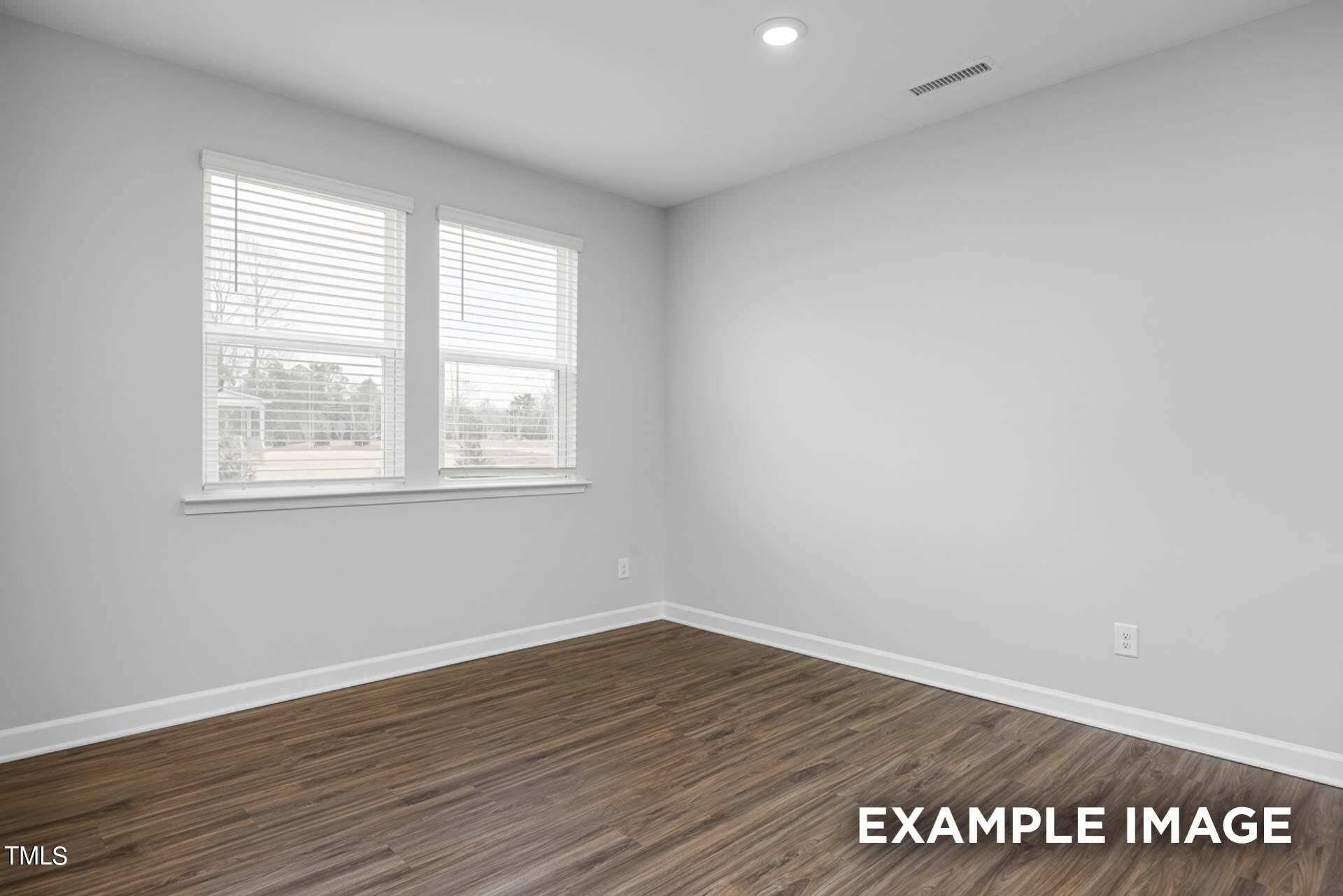 802 Rollingwheel Road Mebane, NC 27302 - Photo 18 of 40 a view of an empty room with wooden floor and a window