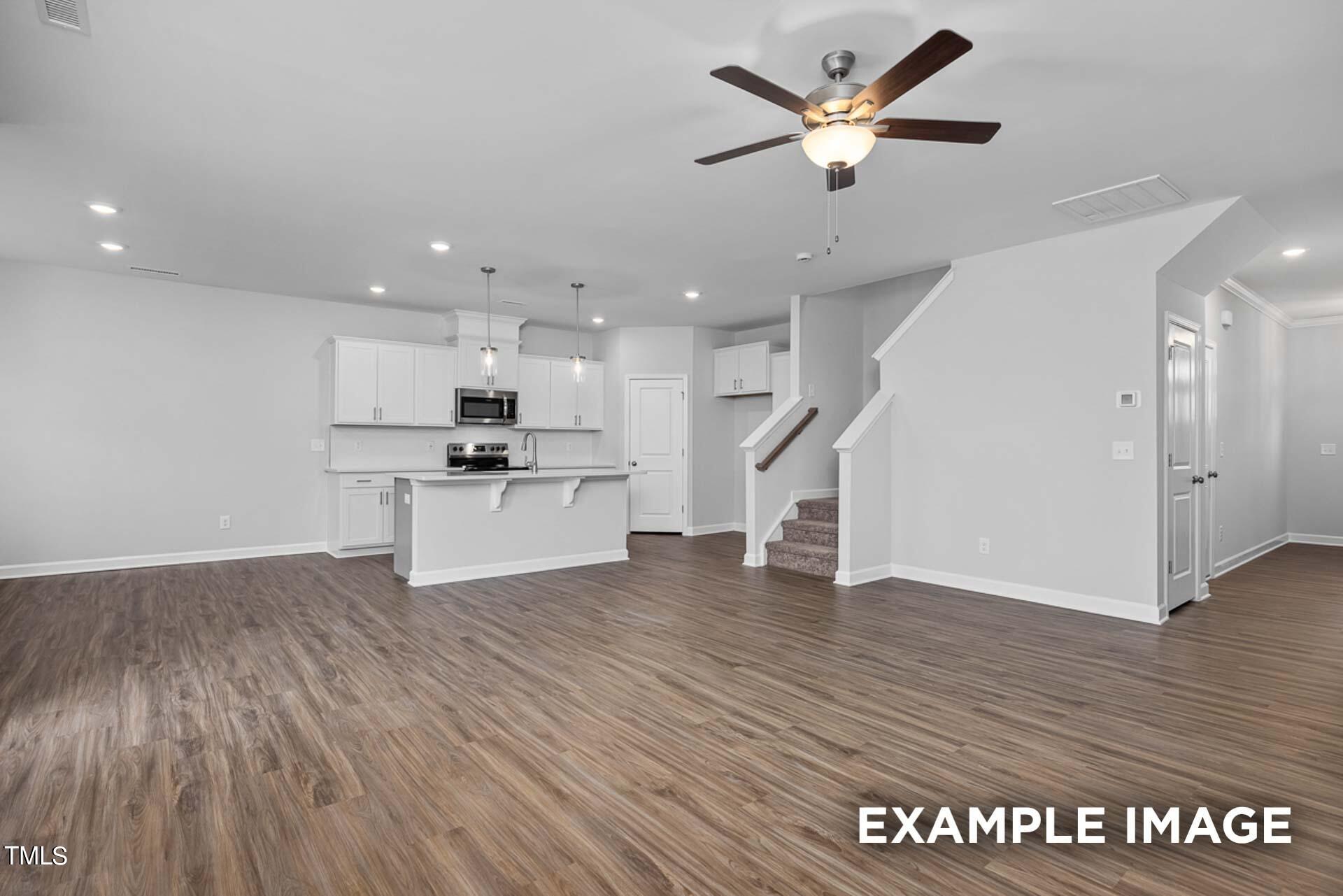 802 Rollingwheel Road Mebane, NC 27302 - Photo 4 of 40 a view of a kitchen with wooden floor and a ceiling fan