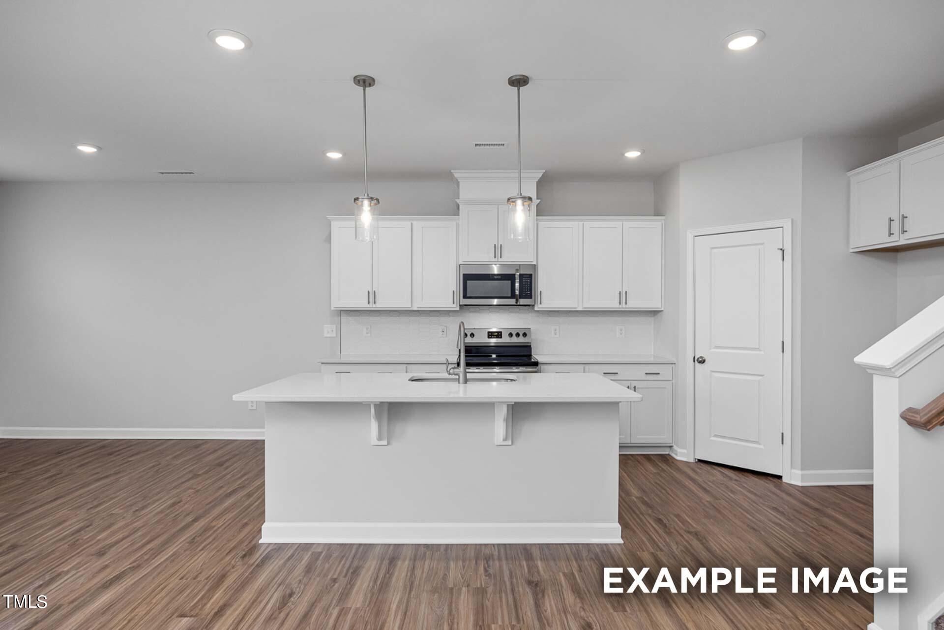 802 Rollingwheel Road Mebane, NC 27302 - Photo 7 of 40 a kitchen with kitchen island a sink stainless steel appliances and cabinets