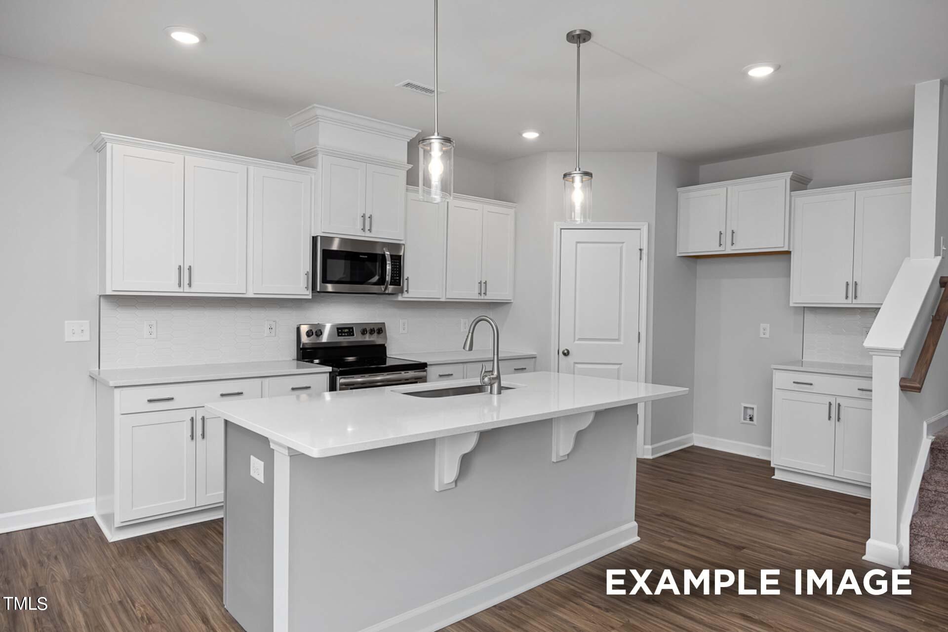 802 Rollingwheel Road Mebane, NC 27302 - Photo 8 of 40 a kitchen with a sink a stove a refrigerator and white cabinets