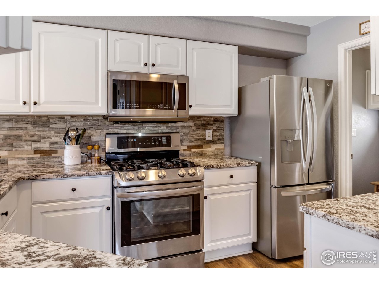 11737 Zenobia Loop Westminster, CO 80031 - Photo 12 of 39 a kitchen with a stove microwave and refrigerator