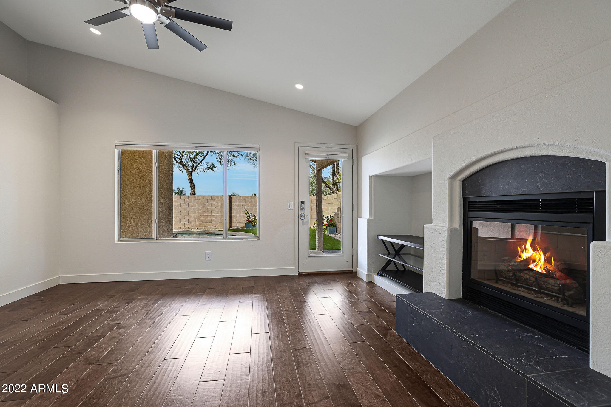 4316 East Rowel Road Phoenix, AZ 85050 - Photo 11 of 40 an empty room with wooden floor fireplace and windows