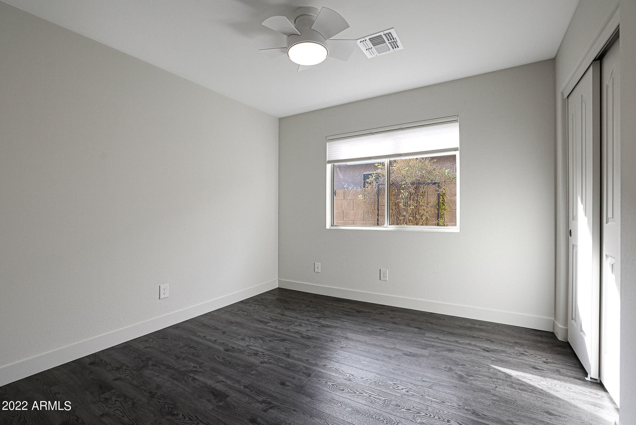 4316 East Rowel Road Phoenix, AZ 85050 - Photo 27 of 40 an empty room with wooden floor and windows