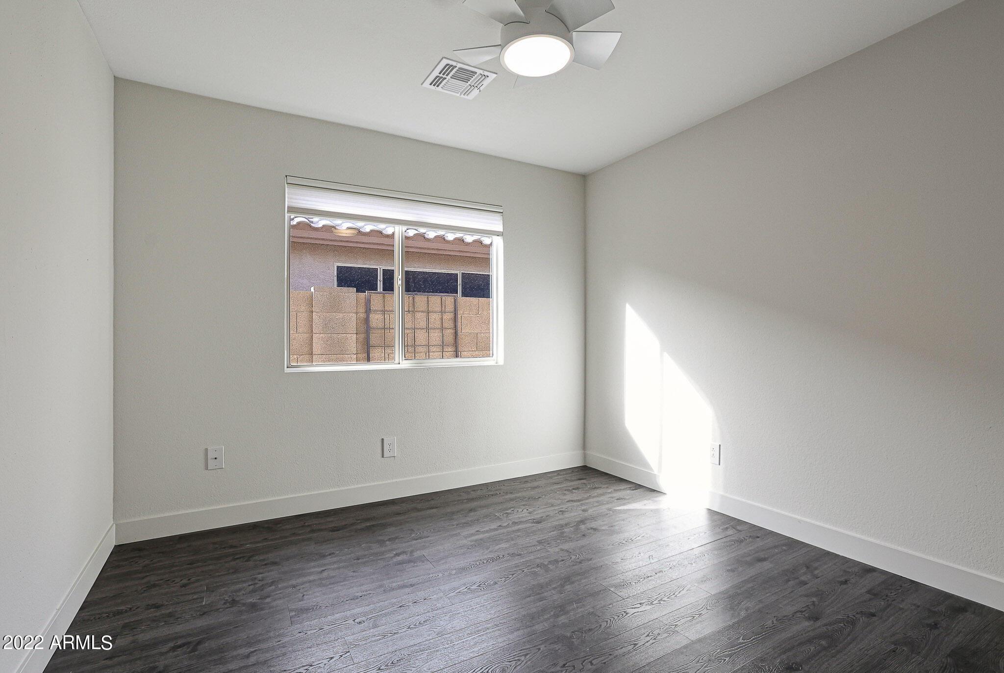 4316 East Rowel Road Phoenix, AZ 85050 - Photo 28 of 40 an empty room with wooden floor and windows