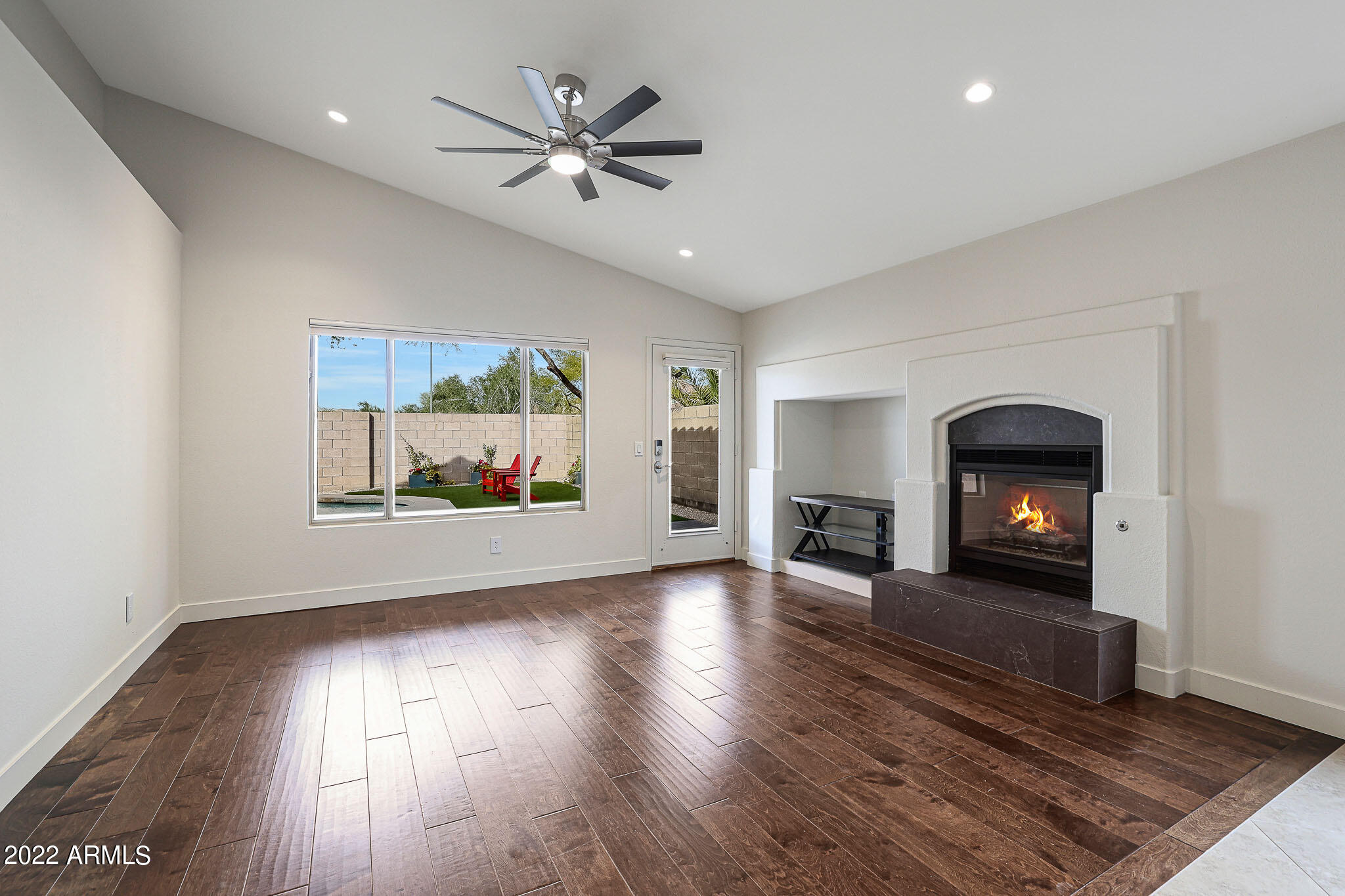 4316 East Rowel Road Phoenix, AZ 85050 - Photo 9 of 40 an empty room with wooden floor fireplace and windows