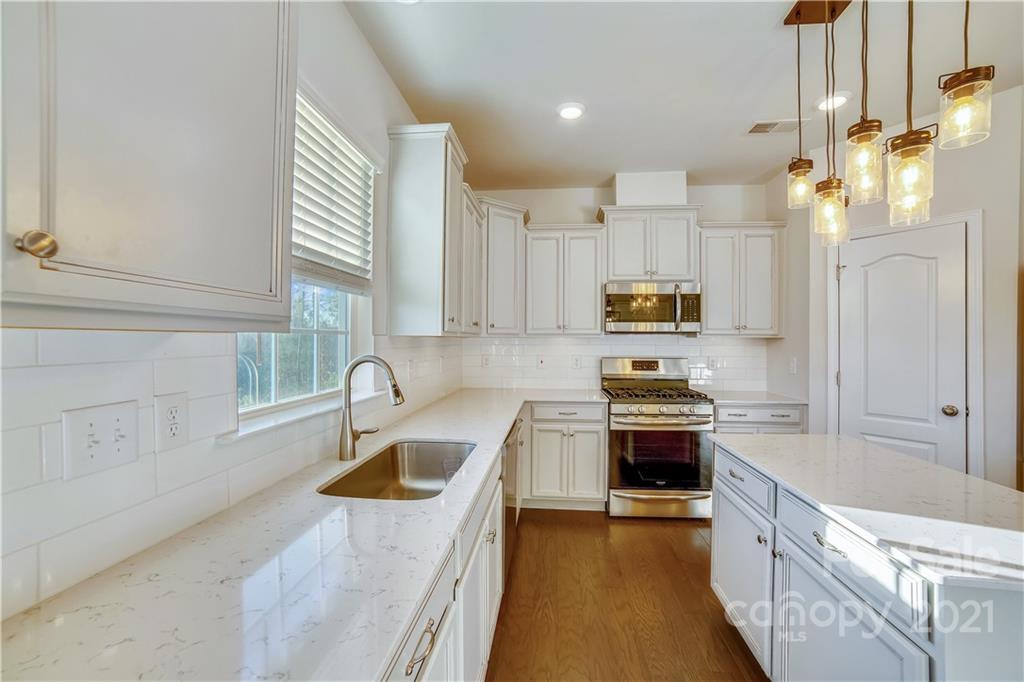 18121 Kalabash Road, Unit 195 Charlotte, NC 28278 - Photo 13 of 39 a kitchen with granite countertop white cabinets and stainless steel appliances
