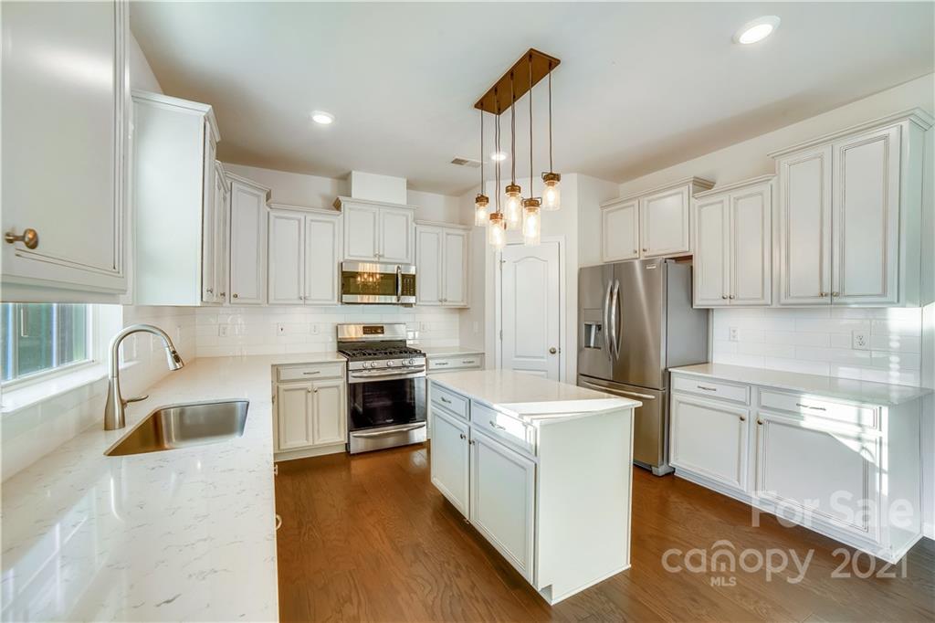 18121 Kalabash Road, Unit 195 Charlotte, NC 28278 - Photo 14 of 39 a kitchen with refrigerator a sink and white cabinets
