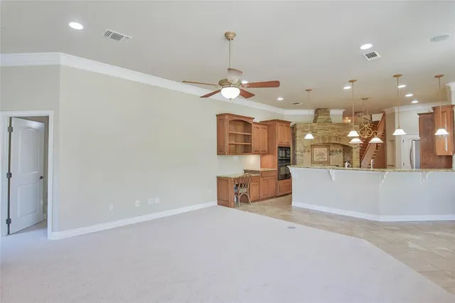 a view of an empty room and kitchen with granite countertop a flat screen tv