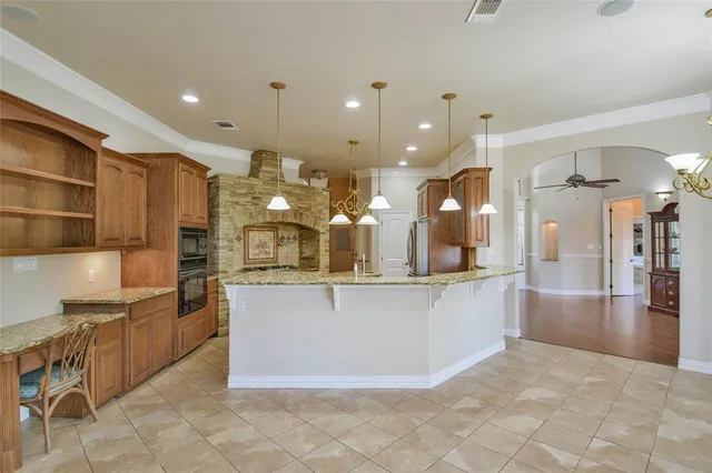 a large kitchen with kitchen island granite countertop a large kitchen island and a sink