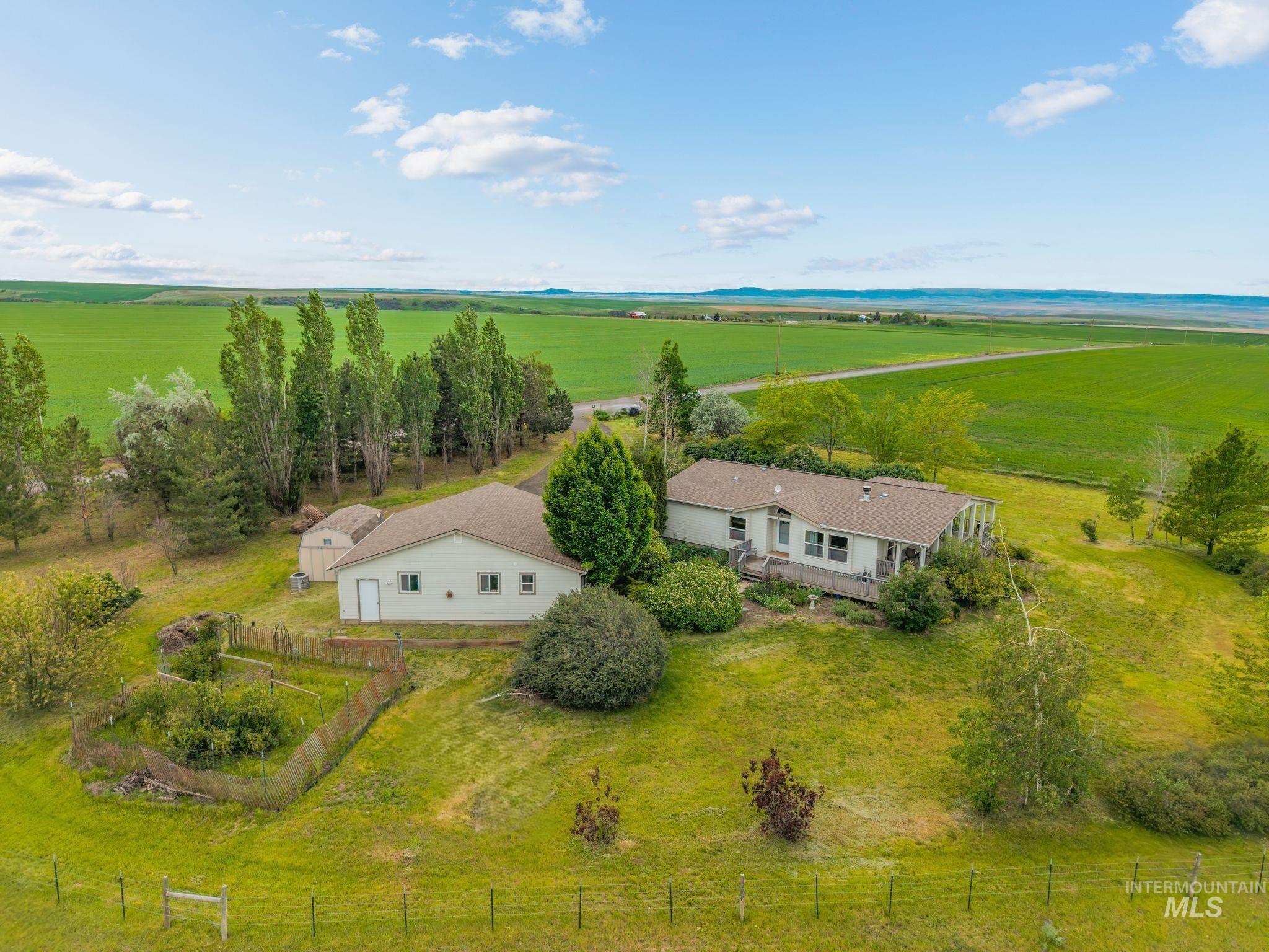 37989 Rosenkrantz Road Lewiston, ID 83501 - Photo 2 of 50 Expansive rural property featuring a primary residence with an extended deck, a detached outbuilding, and significant acreage