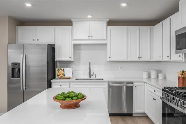 a kitchen with stainless steel appliances a refrigerator sink and cabinets