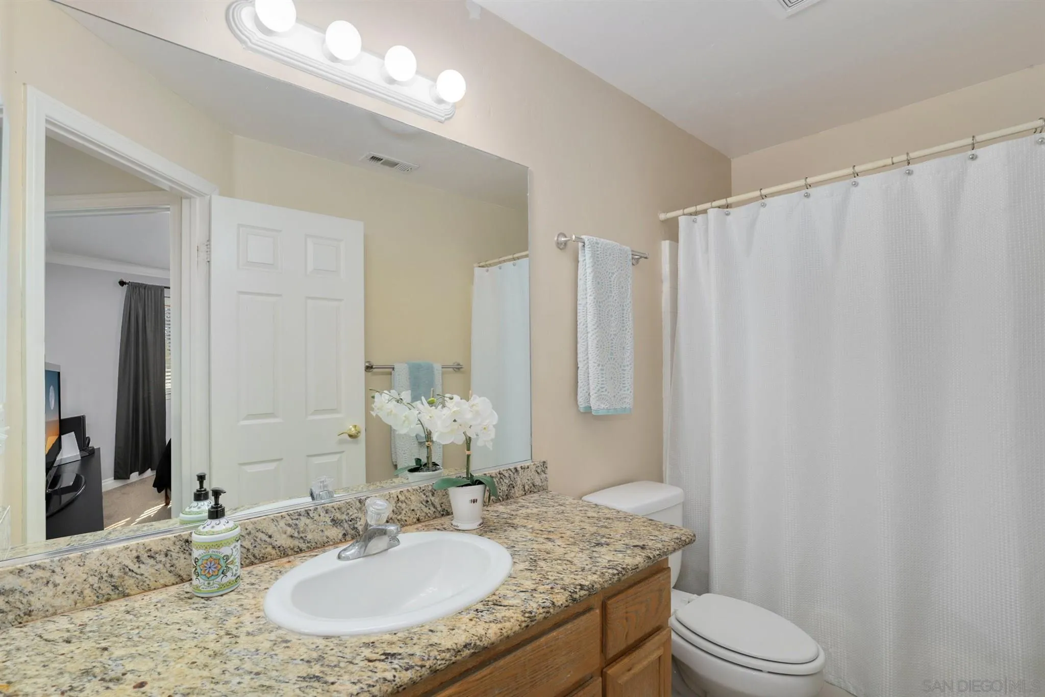 7949 Winter View Court El Cajon, CA 92021 - Photo 11 of 27 a bathroom with a granite countertop sink toilet and a mirror