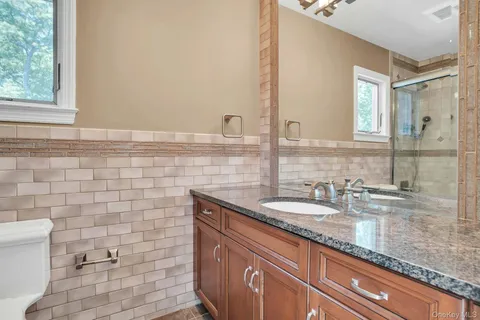 a bathroom with a granite countertop sink and a mirror