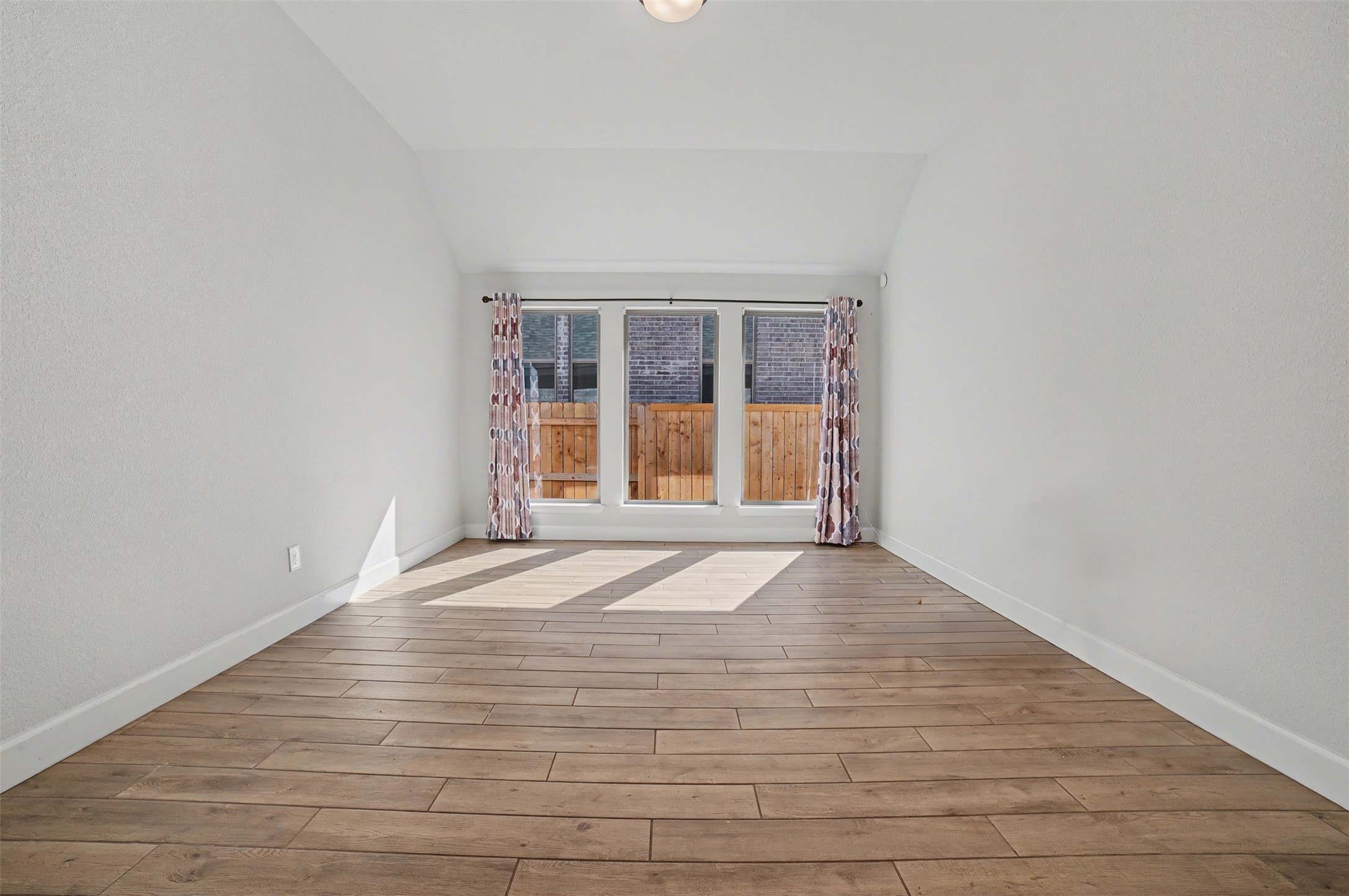 186 Prickly Poppy Loop Kyle, TX 78640 - Photo 14 of 40 an empty room with wooden floor and windows