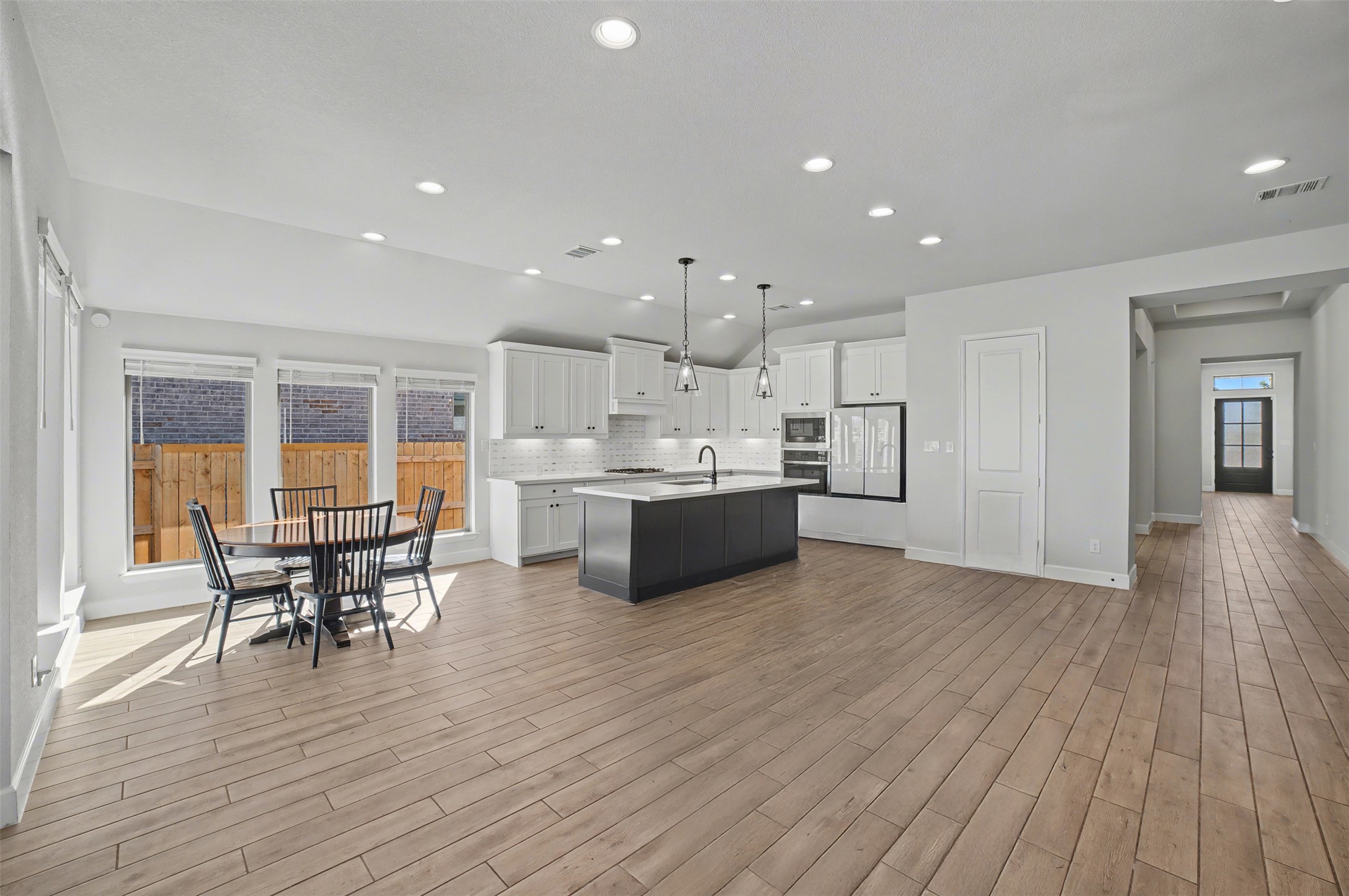 186 Prickly Poppy Loop Kyle, TX 78640 - Photo 39 of 40 a kitchen with stainless steel appliances kitchen island wooden floors and white cabinets