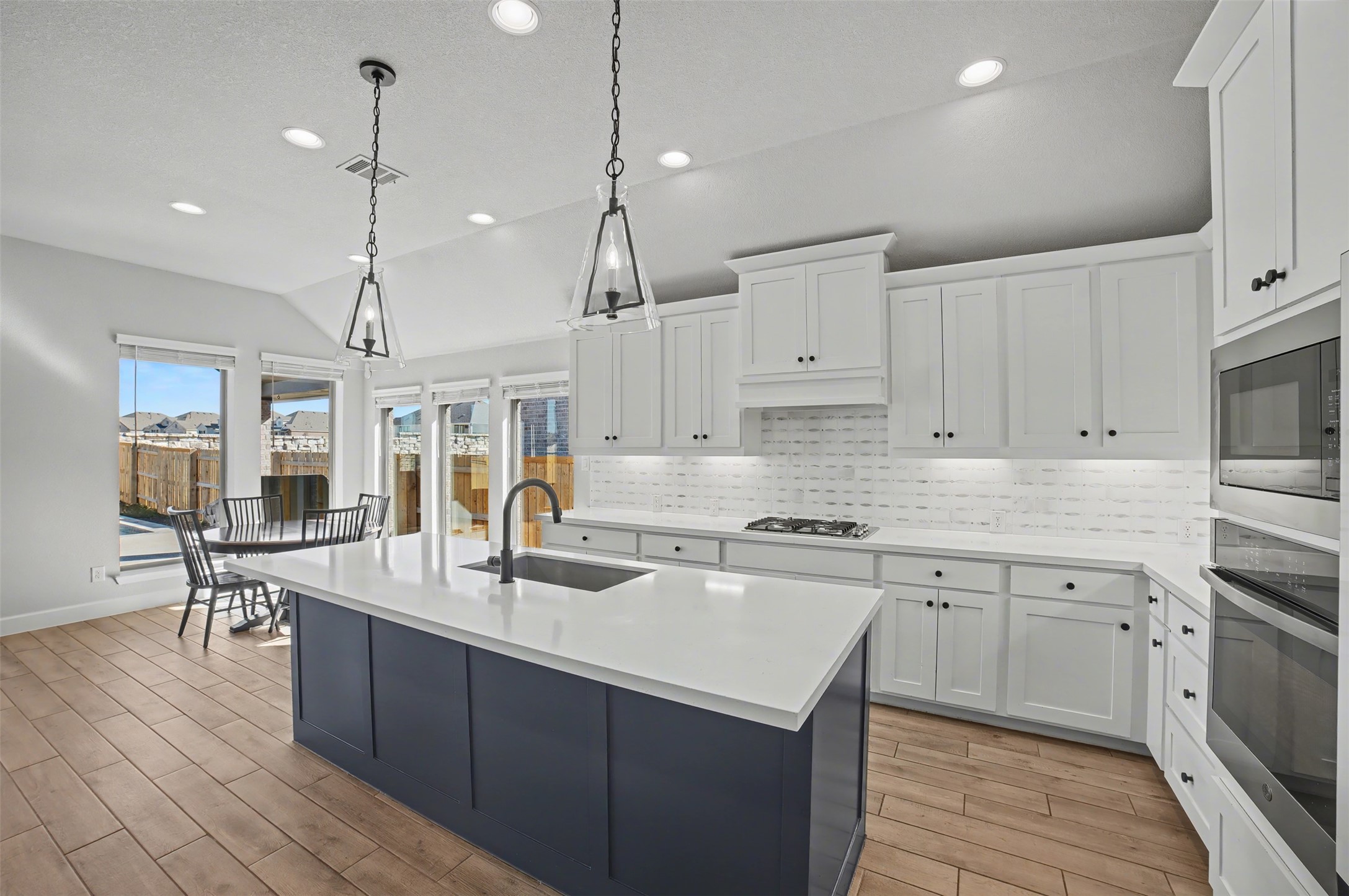 186 Prickly Poppy Loop Kyle, TX 78640 - Photo 5 of 40 a kitchen with stainless steel appliances granite countertop a sink a stove and a wooden floors