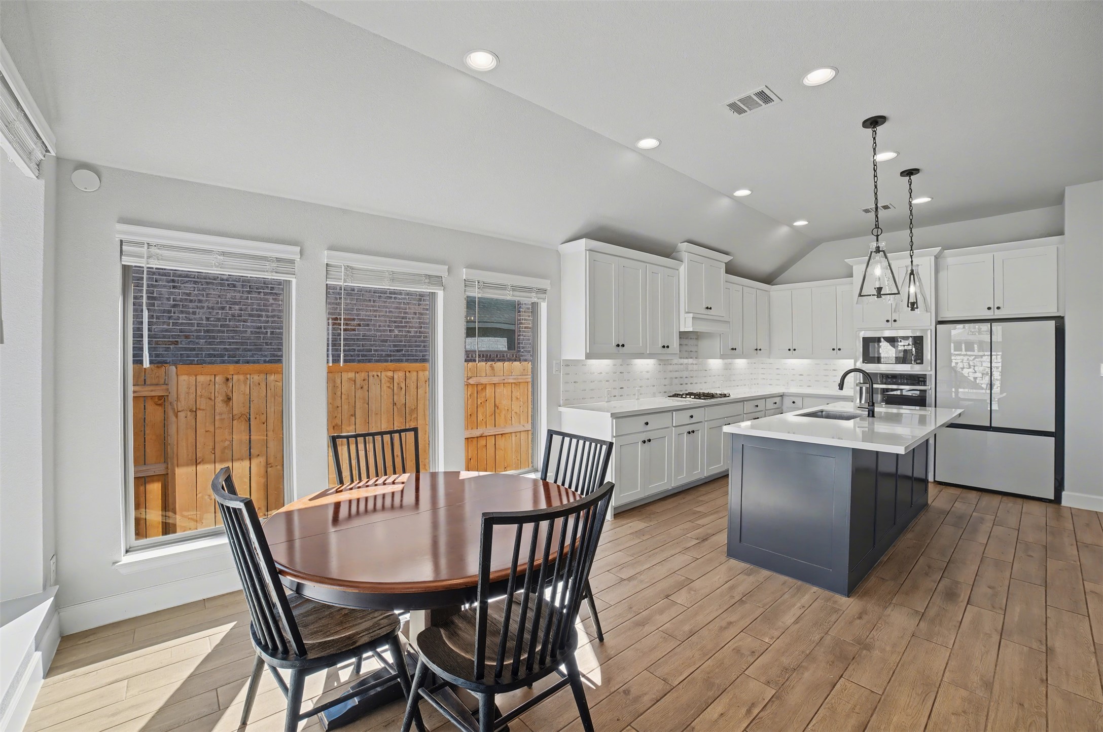 186 Prickly Poppy Loop Kyle, TX 78640 - Photo 6 of 40 a kitchen with a table chairs wooden floors and view living room