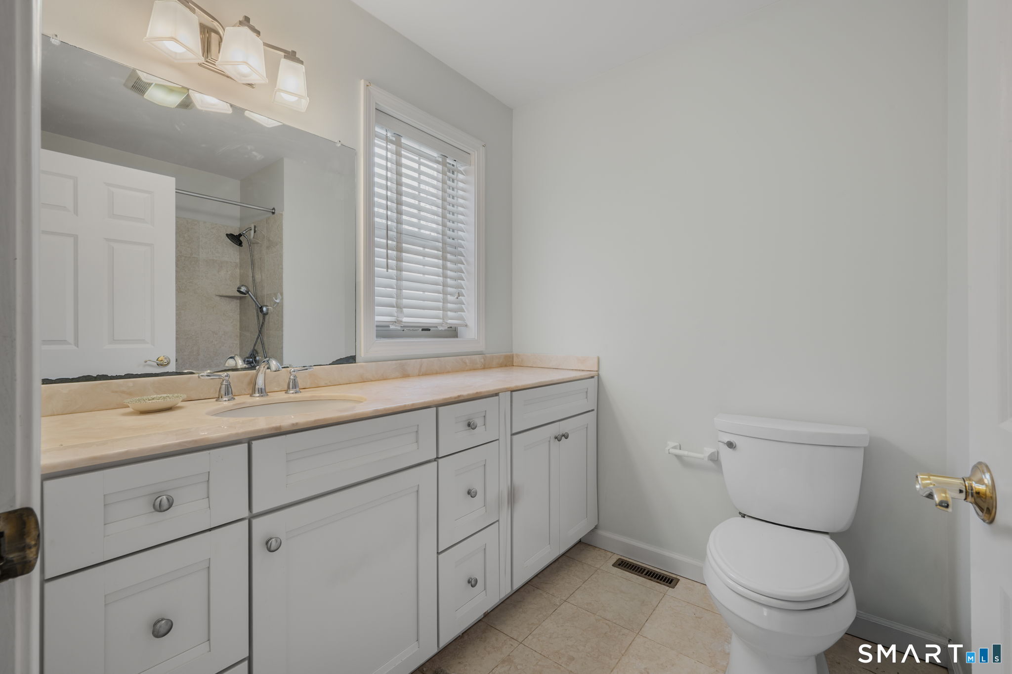1 Bittersweet Lane, Unit 1 East Lyme, CT 06357 - Photo 17 of 26 a bathroom with a granite countertop toilet sink and mirror