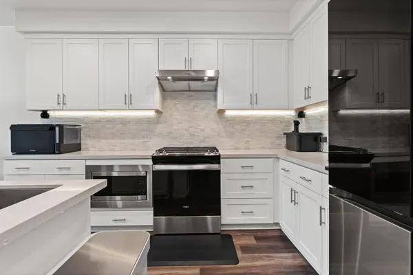 a kitchen with stainless steel appliances a sink stove and cabinets