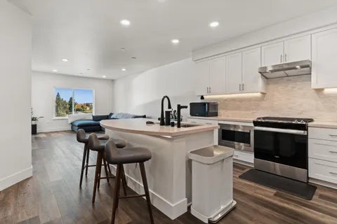 a kitchen with a sink a stove a refrigerator and cabinets