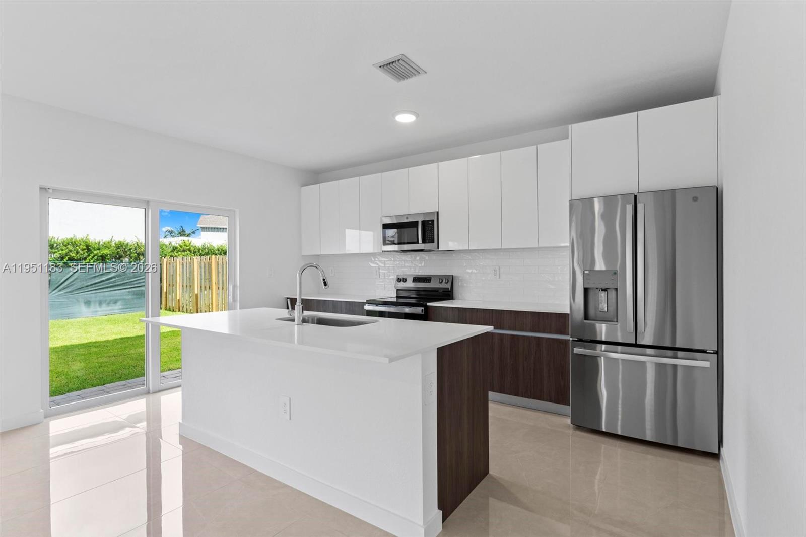 13361 Southwest 272nd Lane Homestead, FL 33032 - Photo 10 of 27 a kitchen with kitchen island a counter top space stainless steel appliances and a large window