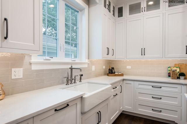 a kitchen with cabinets stainless steel appliances a sink and a window
