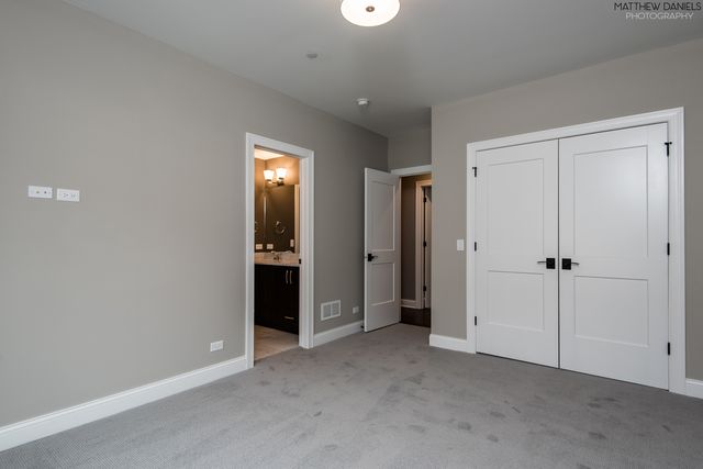a view of an empty room with closet and wooden door