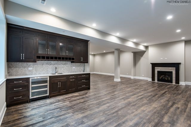 a view of a small house with a small yard and large tree