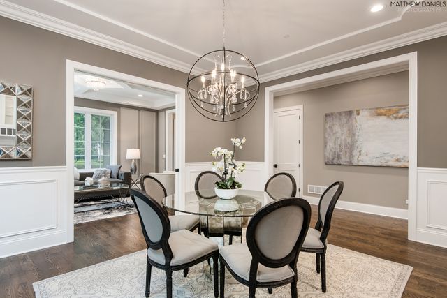 a dining room with furniture a chandelier and wooden floor
