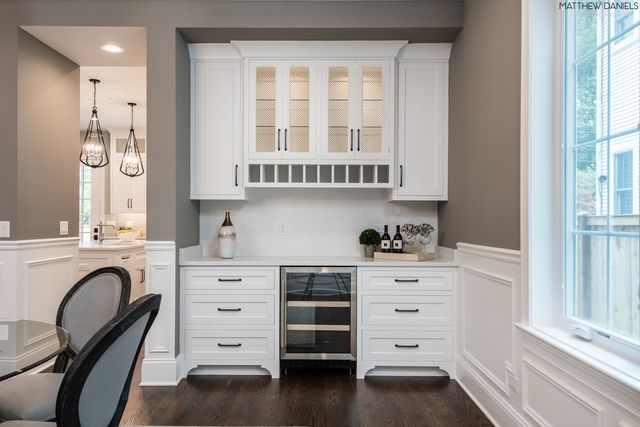a kitchen with granite countertop a window and a white wooden cabinets