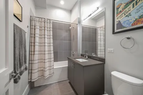a bathroom with a granite countertop sink a toilet and shower