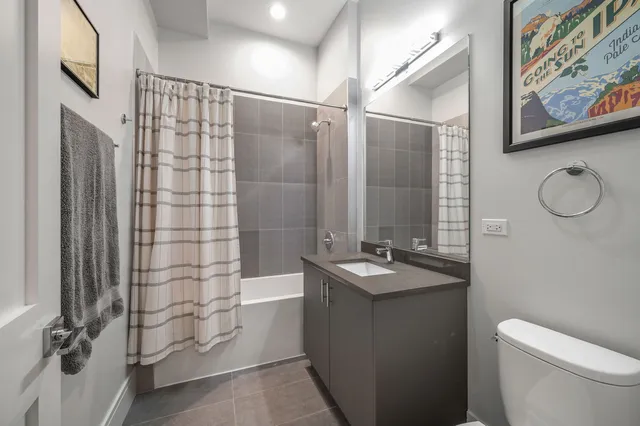 a bathroom with a granite countertop sink a toilet and shower