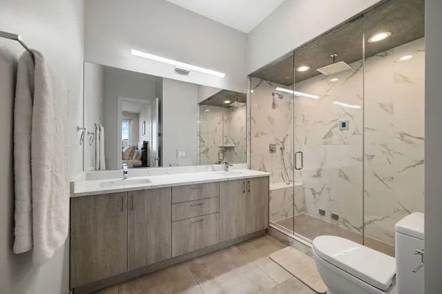 a bathroom with a double vanity sink toilet and shower