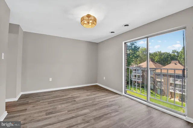 a view of a room with wooden floor and windows