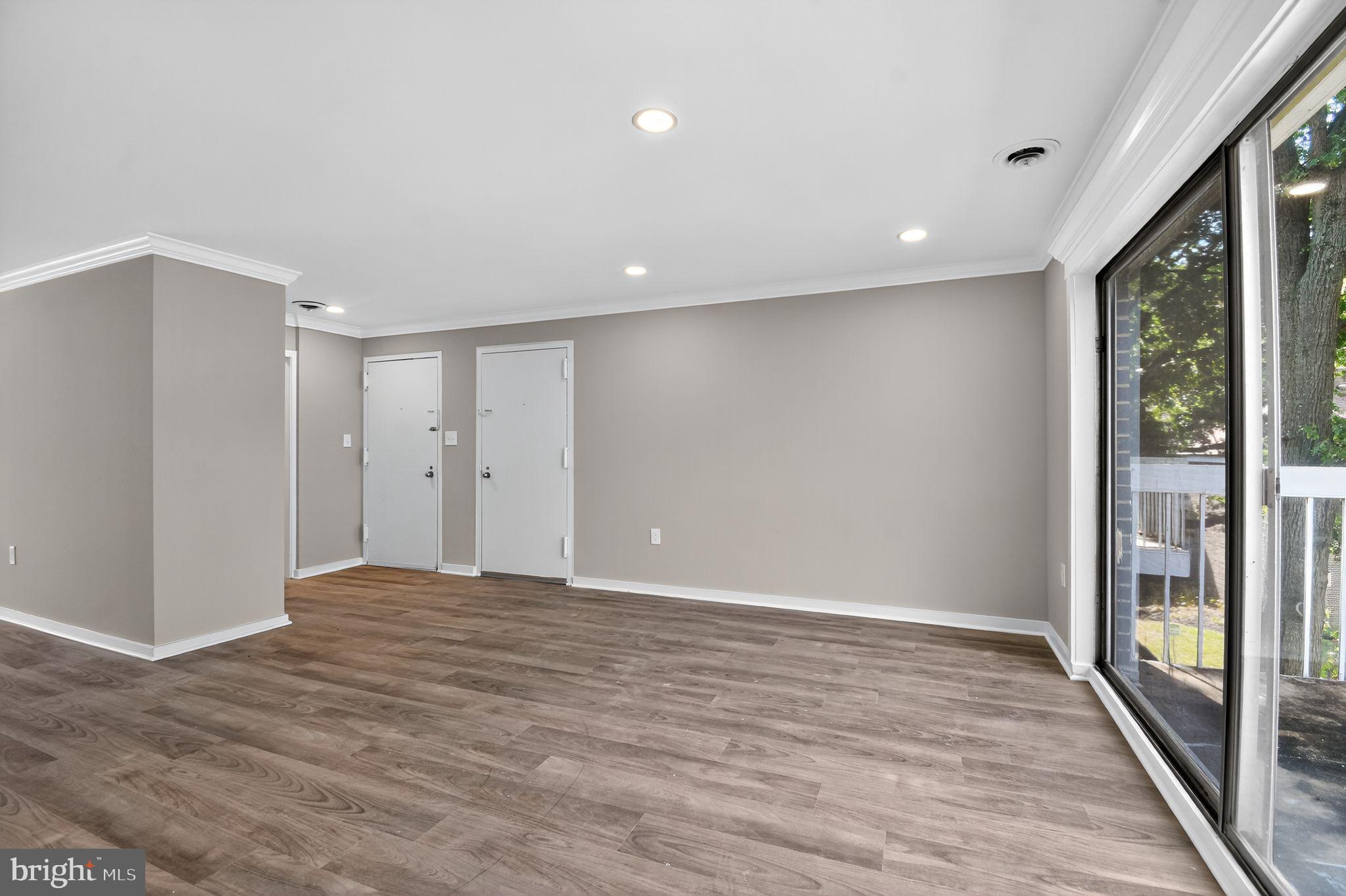 3234 Hewitt Avenue, Unit 34B Silver Spring, MD 20906 - Photo 2 of 17 a view of an empty room with wooden floor and a window