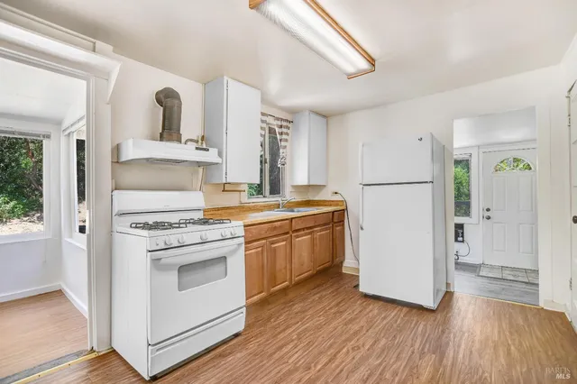 a kitchen with cabinets wooden floor and a fireplace