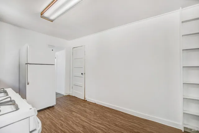 a view of a room with a large window and wooden floor