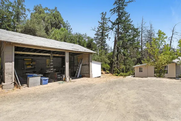 a view of a backyard with table and chairs under an umbrella