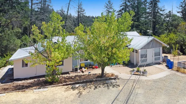 a white house sitting in middle of yard